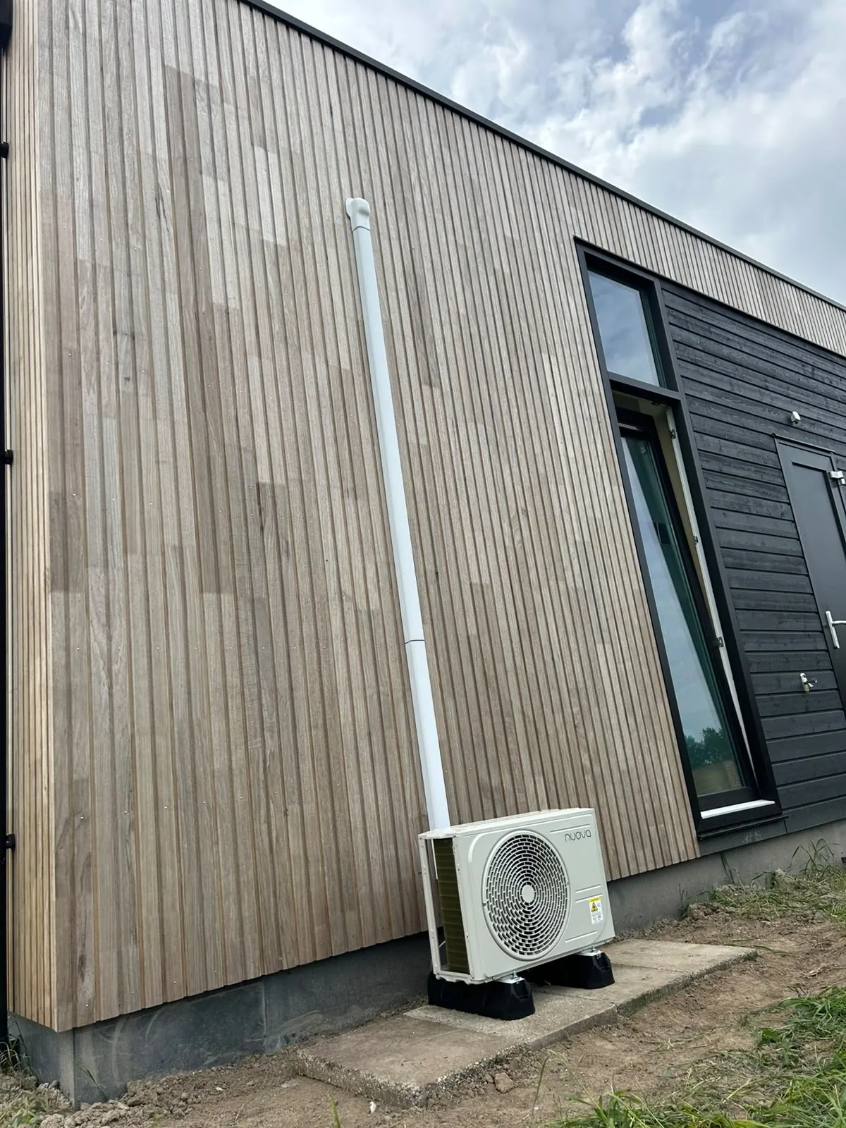 Nuova buitenunit bij houten gevel